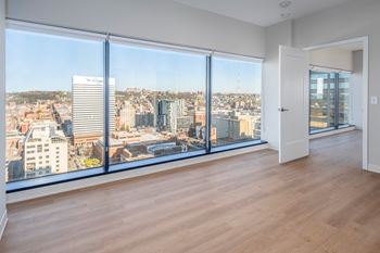 A room with a view of a cityscape through large windows.